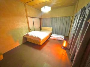 下関市にある自然豊かな隠れ家 ゲストハウス和村Nagomuraのベッドと窓が備わる小さな客室です。