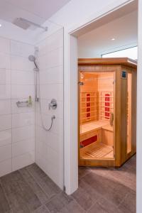 baño con ducha y puerta de madera en Donauoase, en Donaueschingen