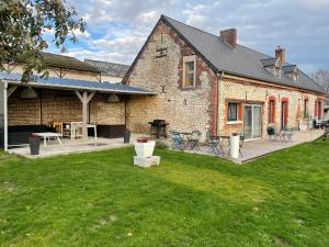 een groot bakstenen huis met een patio en een tuin bij Villa Verger vakantiewoning 12 personen in Cilly
