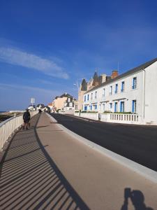 osoba jeżdżąca rowerem na promenadzie obok budynków w obiekcie Residence Hotel de la Plage w mieście Saint-Gilles-Croix-de-Vie