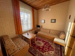 a living room with a couch and a table at Gästehaus Gut Frauendorf in Windorf