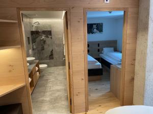 a bathroom with a door leading to a bedroom at Hotel Spöl Restaurant in Zernez