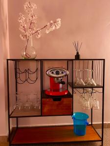 Un estante con vasos y un jarrón con flores. en Altaona Comfort & Calidad Villa en Murcia