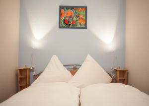 twee witte bedden in een kamer met een schilderij aan de muur bij Lindenhof am See in Winterberg