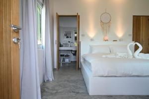 瑤海灘的住宿－Bao Village，卧室配有白色的床和天鹅