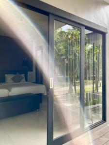 a bedroom with a bed and a sliding glass door at Cede Boutique Beach Resort in Ko Phayam