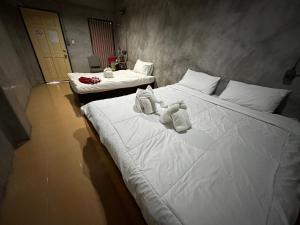 ein Schlafzimmer mit 2 Betten und Handtüchern darauf in der Unterkunft OYO 560 Chang Hostel Suvarnabhumi in Bangkok