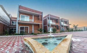 a courtyard with a fountain in front of a building at InnBox Farmstay - Rajpura Punjab in Banūr