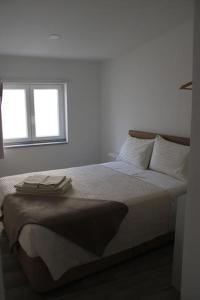 a bedroom with a large bed with two windows at Casa Maria Inácia T2 in Évora