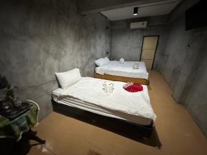 2 camas en una habitación con sábanas blancas y toallas en OYO 560 Chang Hostel Suvarnabhumi, en Bangkok