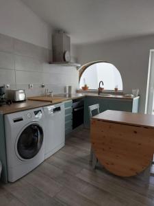 a kitchen with a washing machine and a table at Casa Maria Inácia T2 in Évora
