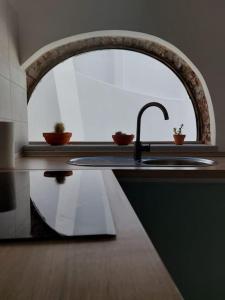 a kitchen counter with a sink and a mirror at Casa Maria Inácia T2 in Évora +36 photos