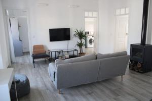 a living room with a couch and a tv at Casa Maria Inácia T2 in Évora