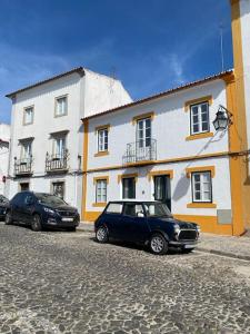 two cars parked in front of a building at Casa Maria Inácia T2 in Évora
