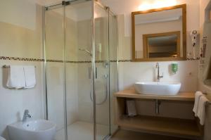 a bathroom with a glass shower and a sink at Parc Hotel Tyrol in Castelrotto