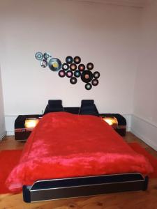 a bedroom with a red bed with a red blanket at Vintage ,le paradis des enfants wifi draps parking free in Thiers