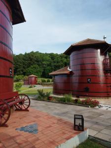 um celeiro vermelho com um banco ao lado de um edifício em Pousada Botte di Vino em Garibaldi