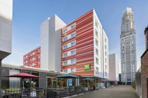 um edifício vermelho e branco numa cidade com edifícios altos em ibis Styles Amiens Centre em Amiens