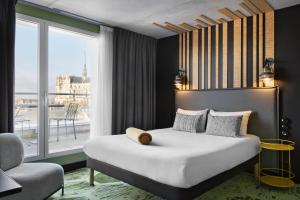 een slaapkamer met een bed en een groot raam bij ibis Styles Amiens Centre in Amiens