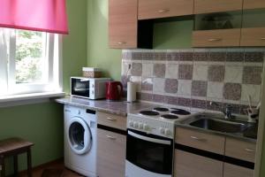 a kitchen with a washing machine and a microwave at Apartments near the center and airport in Tallinn