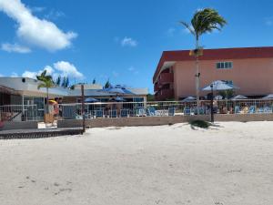 a resort with chairs and umbrellas on the beach at Apartamento no Golden Lake - pé na areia, agua de côco e cervejinha in Arraial do Cabo
