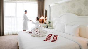 a man and a woman in a hotel room at Muong Thanh Grand Quang Tri Hotel in Quang Tri