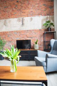 a living room with a brick wall and a coffee table at RedCity LOFT 309 in Żyrardów