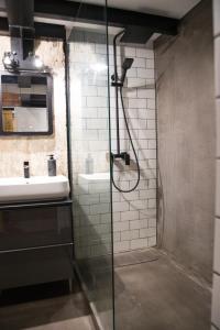 a bathroom with a glass shower and a sink at RedCity LOFT 309 in Żyrardów