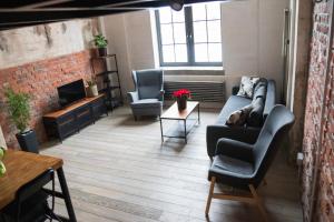 a living room with a couch and chairs and a fireplace at RedCity LOFT 309 in Żyrardów