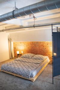 a bed in a room with a brick wall at RedCity LOFT 309 in Żyrardów