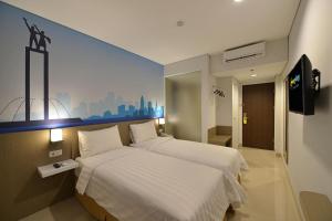 a bedroom with a large white bed in a room at Moritz Biz Gandaria in Jakarta
