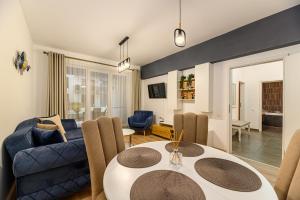 a living room with a table and a blue couch at Luxury Landing Apartments Complex Qualis Brasov in Braşov