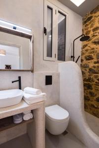 La salle de bains est pourvue d'un lavabo, de toilettes et d'un miroir. dans l'établissement Athena Luxury Studios, à Athènes