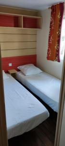 フレジュスにあるREGENCY HOLIDAY Tour Opérateur dans Camping 5 étoiles Frejus, Cote d'Azurの窓付きの小さな部屋のベッド2台