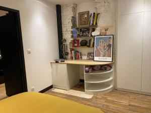 Zimmer mit einem Schreibtisch und einem Regal mit Büchern in der Unterkunft CAPUCINE in Bourges