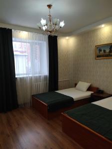 Habitación de hotel con 2 camas y lámpara de araña. en Гостиница ,,Меркурий и К,, en Astaná