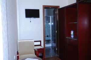 a room with a chair and a television and a door at Guzara Hotel Addis in Addis Ababa