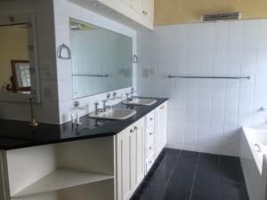 a bathroom with two sinks and a mirror at A boutique lodge situated in a serene environment - 2023 in Harare