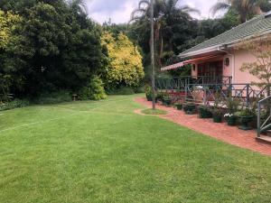 a yard with green grass and a house at A boutique lodge situated in a serene environment - 2023 in Harare