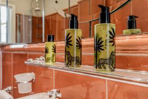 a group of four bottles on a shelf in a bathroom at APT ROME - Pietra in Rome +33 photos