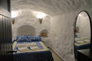 a bedroom with a bed in a snowy room at Casas Cueva con piscina y barbacoa in Fontanar