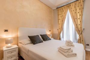 a bedroom with a white bed with towels on it at APT ROME - Pietra in Rome