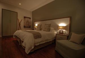 a bedroom with a large bed and a chair at The 5 Stars Sandalwood Lodge in Mount Pleasant - 2020 in Kingsmead