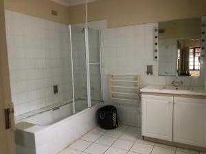 uma casa de banho com uma banheira e um lavatório em A boutique lodge situated in a serene environment - 2021 em Harare