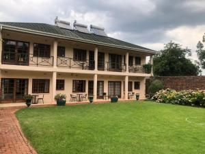 un edificio con un prato davanti di A boutique lodge situated in a serene environment - 2021 a Harare