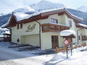 a building with snow on the ground in front of it at RAFFL APART in Sankt Anton am Arlberg