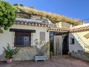 a house with a door and a hill at Casas Cuevas ElMirador in Fontanar