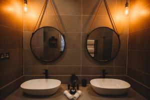 a bathroom with two sinks and two mirrors at 5 Stars Sandalwood Lodge is situated in Mount Pleasant - 2019 in Kingsmead