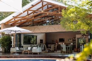 a patio with a pool and tables and chairs at 5 Stars Sandalwood Lodge is situated in Mount Pleasant - 2019 in Kingsmead