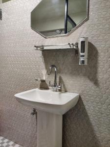 a white sink in a bathroom with a mirror at HeiJo's Homestay in Jowai